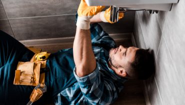 selective focus of repairman fixing water damage in bathroom
